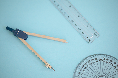 Compass and ruler with a blue background