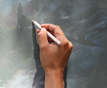 a hand steching on a blackboard