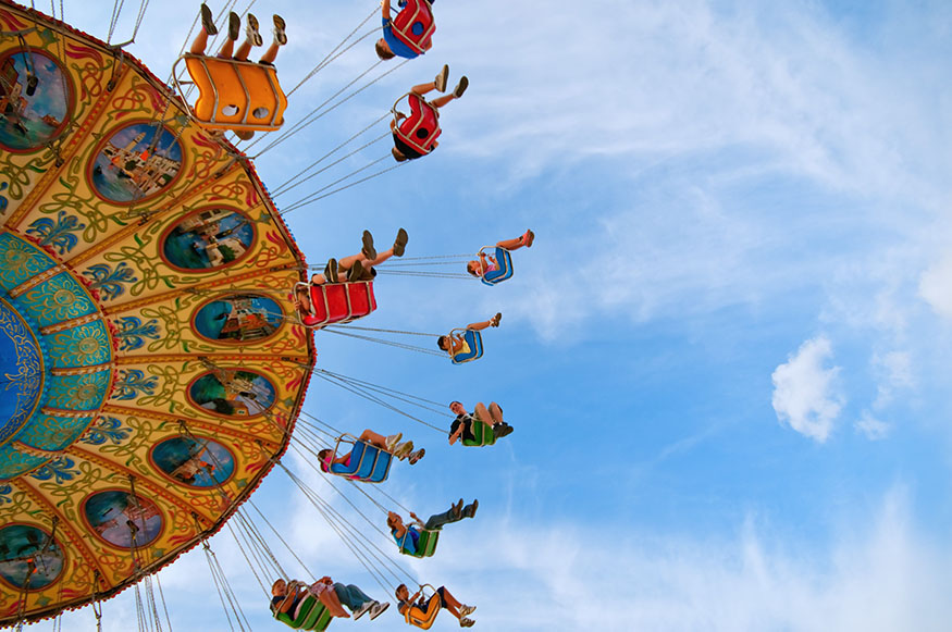 people riding a spinning swing at a carnival