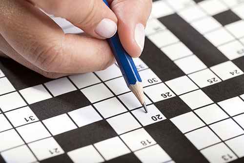 person completing a crossword puzzle