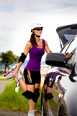 woman stretching near car with rollerblades on