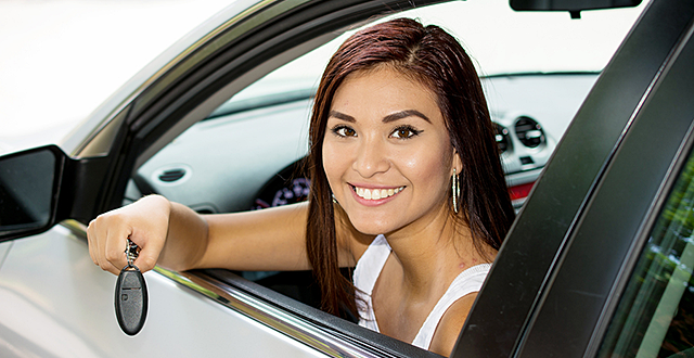 teen in a car and holding a key out the window