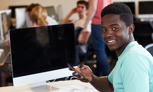 Happy student with a computer and a smart phone