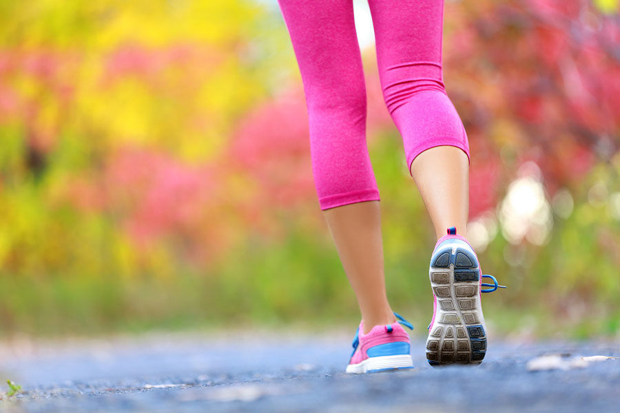 lower body of woman running on pavement