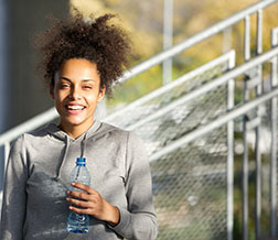 woman in athletic gear drinking water