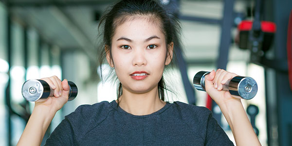 female using dumbbells at the gym