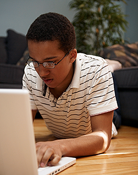 Teen typing on a laptop