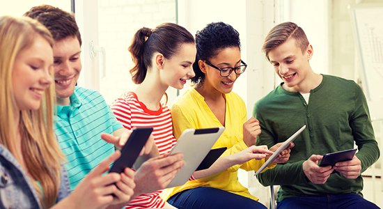 Group of five students using tablets