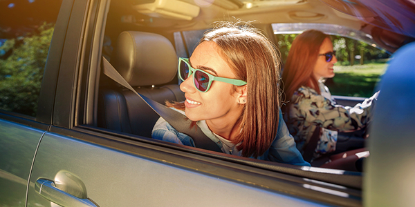 Teen with sunglasses looking out the car window