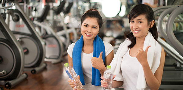 two teens giving a thumbs up in the gym