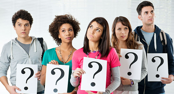 five teens holding question mark signs