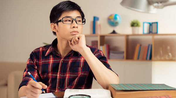 male writing at a desk