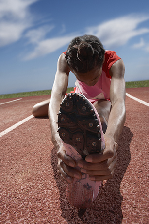 Female track runner stretching