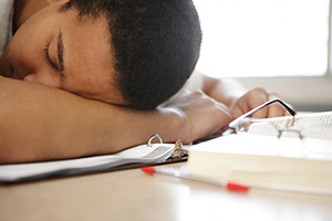 Teenager sleeping at desk