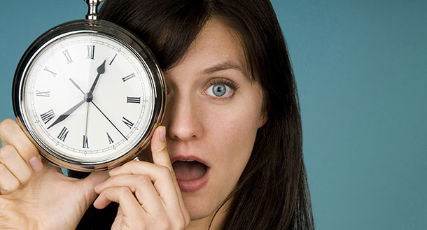 Teenager hold a clock with a surprised look