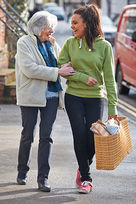 Teenager helping her grandmother carry groceries