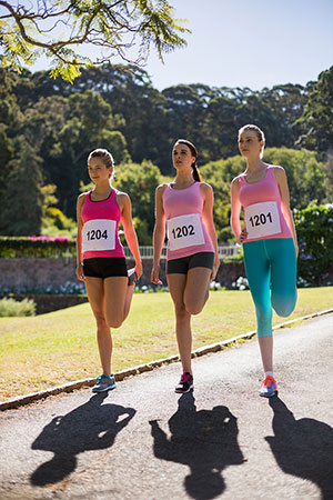 Three girls stretching during a warm-up