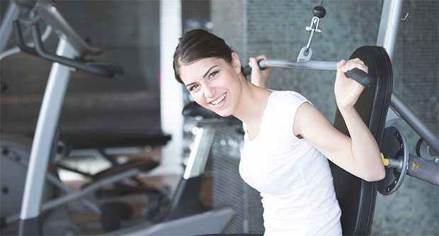 Girl using an upper-body exercise machine