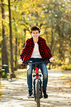 Teenager riding a bike without a helmet