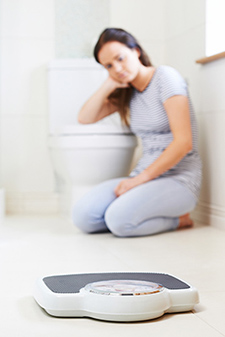 Teenager in bathroom looking at scale