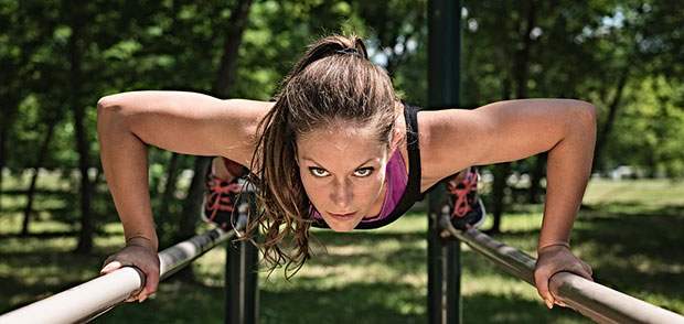 Girl doing a push-up on the parallel bars