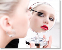 woman applying make-up in mirror