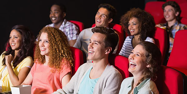 eight young people watching a movie in a theater