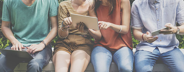 four friends socializing and using tablets