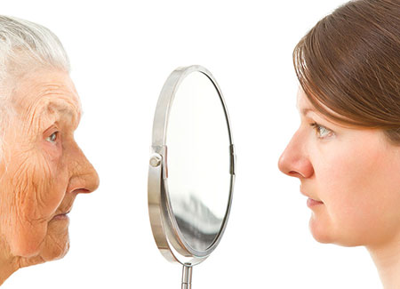 An elderly woman and a young woman looking in the mirror