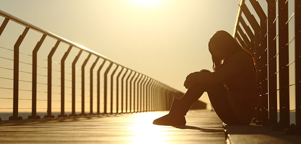 Depressed teenager sitting on a bridge