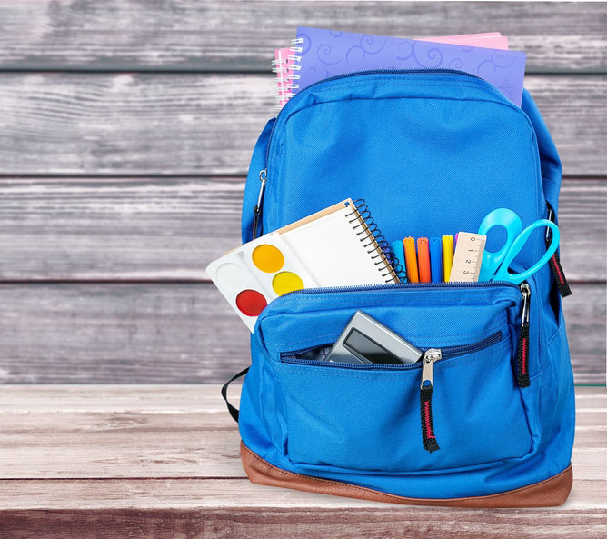 backpack with notebooks, a paint palette, pens, a ruler, scissors, and a calculator coming out of the open pockets