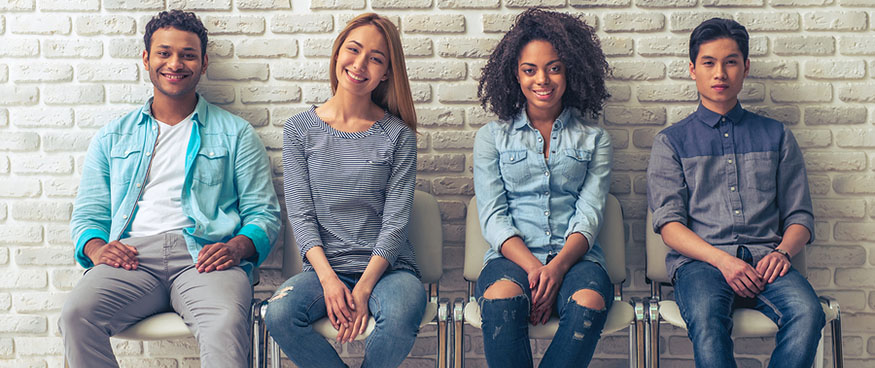 four young people sitting in chairs