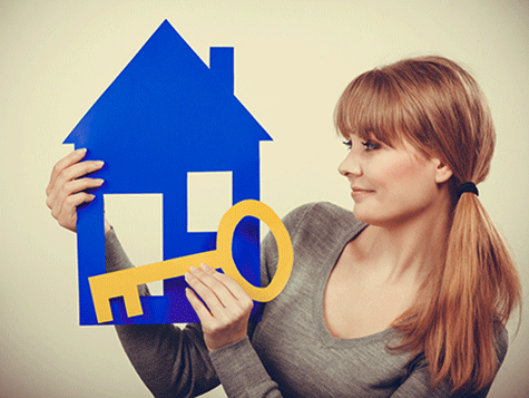 female holding a paper house and key